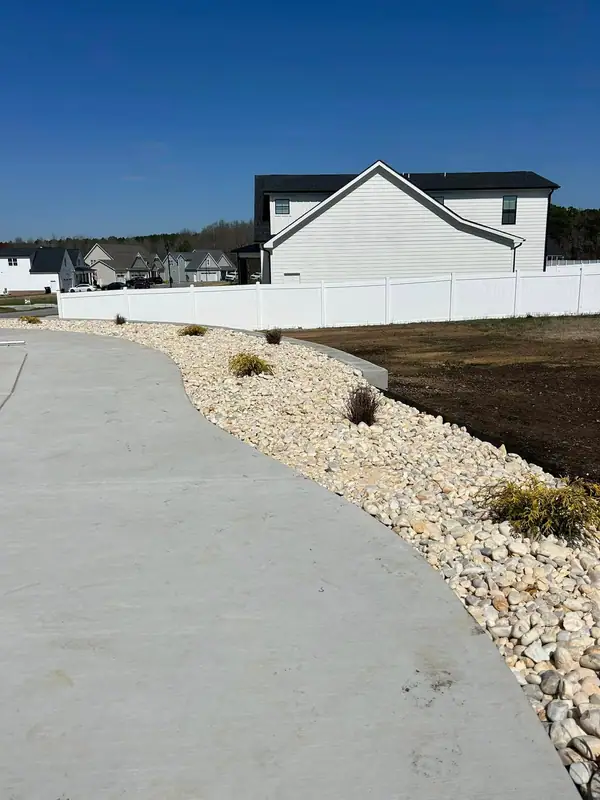 River rock bed curving along a concrete walk
