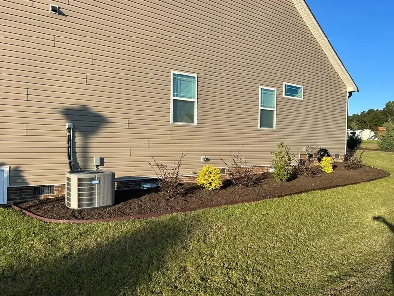 Fresh mulch bed along a sided home